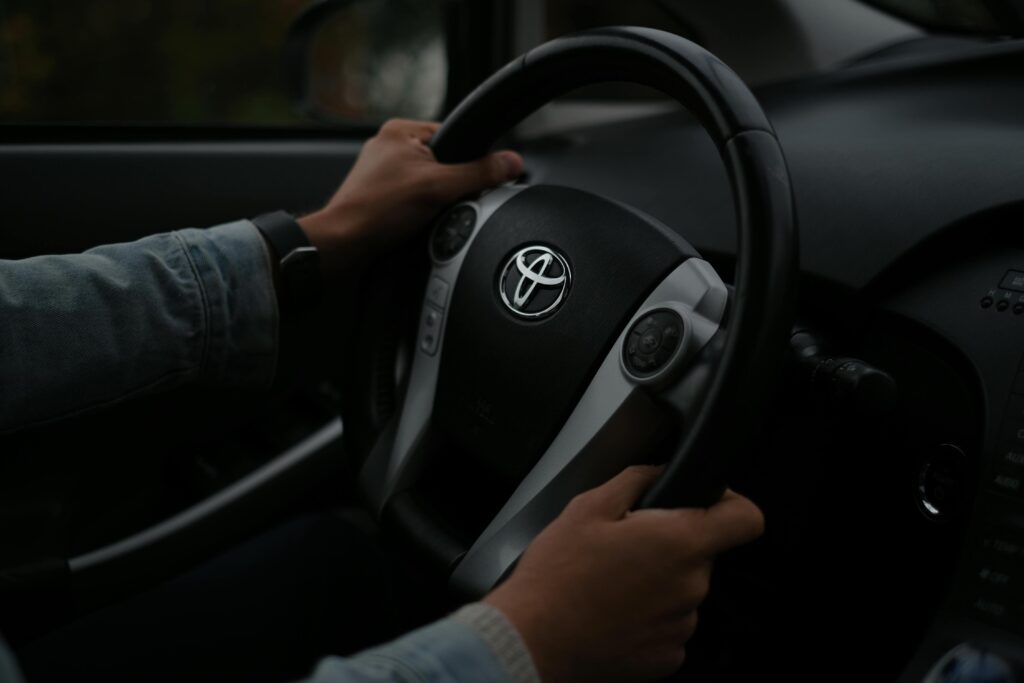 man met handen aan het stuur in een auto
